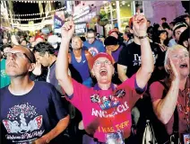  ??  ?? DONALD’S DEVOTEES: Trump supporters on the streets outside the convention watch the nominee via video.