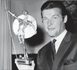  ?? THE ASSOCIATED PRESS ?? British actor Roger Moore poses with Spain’s most prized award, the Don Quixote Award, which was presented to him in 1968.
