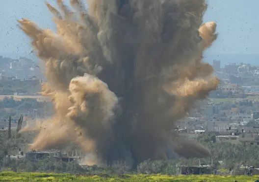  ?? OHAD ZWIGENBERG/AP ?? Smoke and debris rise Wednesday as the result of an explosion in the Gaza Strip as seen from southern Israel.