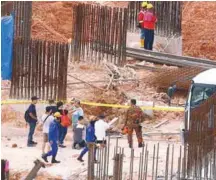  ??  ?? Family members of a victim praying at the constuctio­n site yesterday.