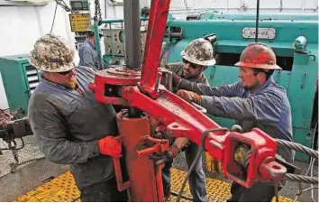  ?? Reuters ?? Slowing down Drillers at a wellhead outside Watford, North Dakota. Output from tight-rock formations such as North Dakota’s Bakken shale will decline by 57,000 barrels a day in May, the EIA said.