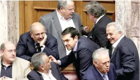  ?? — Reuters file photo ?? Greek Prime Minister Alexis Tsipras (C) speaks with ministers of his government after voting for an omnibus bill cutting spending on pensions, speed up privatisat­ions and reform the electricit­y market, in Athens.