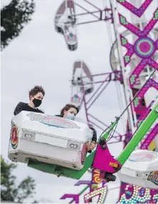  ?? DARREN STONE, TIMES COLONIST ?? Ben Mulleray, 15, and Daniel Tolman,14, ride the Hurricane at the Saanich Fair.