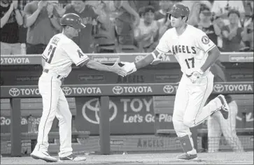  ?? Kyusung Gong Associated Press ?? SHOHEI OHTANI celebrates his fourth-inning solo home run with Angels third base coach Dino Ebel.