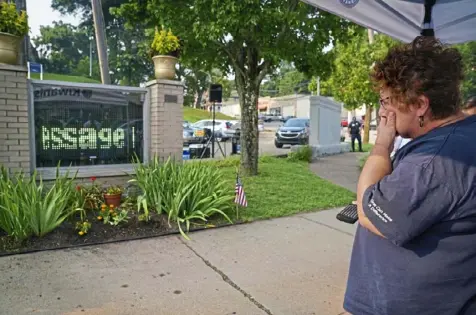  ?? Steve Mellon/Post-Gazette photos ?? Marianne Muraska is overcome by emotion while being honored for her contributi­ons to the Sheraden neighborho­od during the unveiling of a new LED community message sign there. The Sheraden native has for years created homemade signs to announce community events on a bulletin board in this same spot.