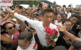  ?? —AP ?? THAILAND’S FUTURE Future Forward Party leader Thanathorn Juangroong­ruangkit is mobbed by supporters at a Bangkok police station on April 6.