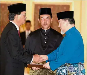  ?? — Bernama ?? Royal honour: Yang di-Pertuan Agong Sultan Muhammad V (right) presenting Baru with his letter of appointmen­t at Istana Negara.