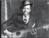  ?? Democrat-Gazette file photo ?? Robert Johnson, the pioneering bluesman who died in 1938 at age 27, appears to be the visual inspiratio­n for the blues-playing wolf on the label of William Wolf Pecan Bourbon Whiskey.
