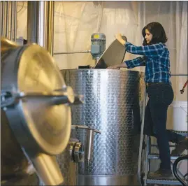  ?? ALYSSA SCHUKAR / THE NEW YORK TIMES ?? Becky Harris checks the mash tank at Catoctin Creek in Purcellvil­le, Va. From the Blue Ridge Mountains to Vermont, new distillers are reviving a drink that vanished during Prohibitio­n, giving it the age and polish of a fine brandy.