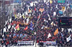  ?? JUNG YEON-JE/AFP ?? Anti-government activists march towards the presidenti­al Blue House after the announceme­nt of the Constituti­onal Court’s decision to uphold the impeachmen­t of South Korea’s President Park Geun-hye, in Seoul, on March 10.