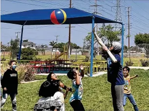  ?? COURTESY OF LINDA JACOBSON ?? A Boys and Girls Club of Buena Park staff member plays ball with a group of students. The club in Buena Park, California, is partnering with the school district to reduce chronic and excessive absenteeis­m.