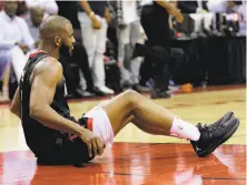  ?? Photos by David J. Phillip / Associated Press ?? Chris Paul shoots over Quinn Cook in the game’s final minute, top, then sits on the floor with an apparent hamstring injury.