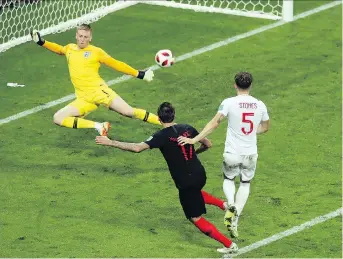  ?? THANASSIS STAVRAKIS/THE ASSOCIATED PRESS ?? Croatia’s Mario Mandzukic, left, scores what proves to be the game-winning goal against England in World Cup semifinal action Wednesday at Luzhniki Stadium in Moscow.