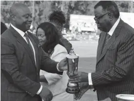  ??  ?? Namibian President His Excellency Hage Geingob (right) hands over a trophy to the Chief Executive Officer of Zimpapers, Mr Pikirayi Deketeke, whose company was judged best Zimbabwean exhibit in Packaging, Plastics, Stationery/Publishing and Printing Sector at the Zimbabwe Internatio­nal Trade Fair yesterday. Following proceeding­s is the ZITF board chairperso­n Ms Ruth Ncube in the background