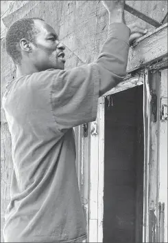  ?? JOHN GURDA PHOTO ?? A worker helps renovate a home in Milwaukee’s Harambee neighborho­od.