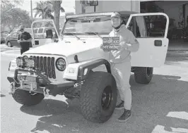  ??  ?? Cancer survivor Jose Miranda holds up the Make-A-Wish sign in front of his Jeep Wrangler in front of Superior Auto Design Shop in Pompano Beach.