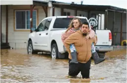  ?? JOSE CARLOS FAJARDO/BAY AREA NEWS GROUP ?? Ryan Orosco carries his wife, Amanda, from their home Monday in Brentwood, Calif. Twenty storm-related deaths have occurred recently.