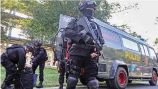  ?? Reuters - Antara Foto/Rony Muharrman/via ?? TAKING POSITION: Indonesian anti-terrorism policeman holds a rifle as others seized crude bombs at Riau University building in Pekanbaru, Sumatra Island, Indonesia, June 2, 2018.