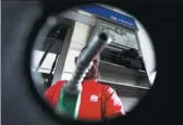  ?? CARLOS JASSO / REUTERS ?? A man poses with a fuel nozzle at a gas station belonging to the state oil company PDVSA in Venezuela on July 21.