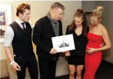  ??  ?? Alec Baldwin truly admires the drawing artist Oje Hart, left, sketched for him of the character he often portrays on SNL POTUS Donald Trump, with his sister Athena and mom, Martha, glowingly looking on.