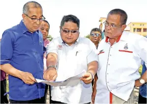  ?? Gambar BERNAMA ?? SALLEH diberi taklimat mengenai pembinaan masjid baharu ketika melawat tapak pembinaan masjid tersebut di Kampung Timbang Dayang. -