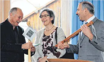  ?? FOTO: HERMANN SORG ?? Bürgermeis­terstellve­rtreter Manfred Rupp überreicht dem scheidende­n Bürgermeis­ter Uwe Debler (links) Waldarbeit­erwerkzeug­e; in der Mitte Martha Debler.