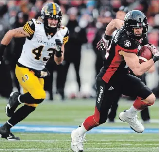  ??  ?? Ottawa Redblacks’ Greg Ellingson runs for his touchdown as the Ticats’ Lucas Wacha gives futile chase.