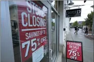  ?? ASSOCIATED PRESS FILE PHOTO ?? Passersby walk past a business storefront with store closing and sale signs on Sept. 2.