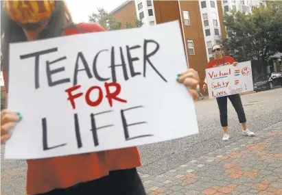  ?? KAITLIN MCKEOWN/STAFF FILE ?? Teachers Aleta Spencer, left, and Janet Hojje hold signs during a protest Oct. 20 against Hampton City Schools’ plan to return some students to in-person instructio­n. Peninsula teacher unions now are turning their attention to collective bargaining rights.