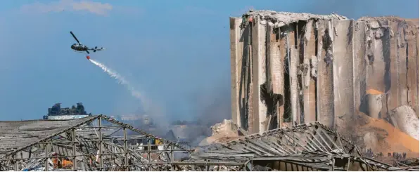  ?? Foto: Getty Images ?? Etwas hilflos wirken die Versuche, die immer noch schwelende­n Glutnester per Helikopter zu löschen. Ein Bild, das Symbolkraf­t hat, denn die Behörden in Beirut sind kaum in der Lage, die Folgen der Katastroph­e in den Griff zu bekommen.