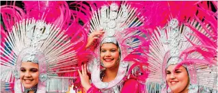  ??  ?? Festival spirit: Carnival-goers in vibrant costume parade the streets of Las Palmas