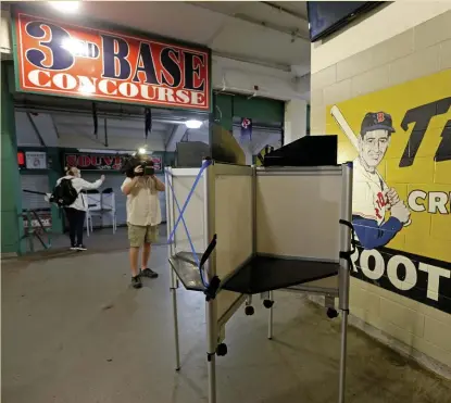  ?? STuART cAHiLL pHOTOs / HeRALd sTAFF ?? CHOOSE YOUR LINEUP: A voting booth is set up Friday on the concourse at Fenway Park, which is hosting early voting starting today. Below left, voters will enter through the old ticket area. Below right, city employees unload voting equipment to set up at the ballpark.