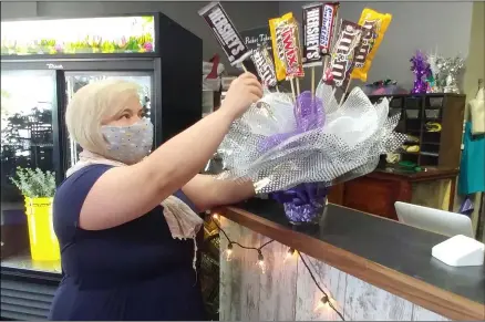  ?? ZACHARY SRNIS — THE MORNING JOURNAL ?? Rachel LaFleur, owner of Enchanted Florist in LaGrange, arranges a candy bouquet.