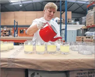  ??  ?? KEEP HOME FIRES BURNING: Helen Barr from Shearer gets to work on the candles. Picture: Stewart Attwood