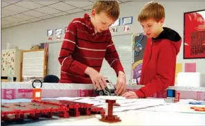  ?? SUBMITTED ?? Cody Tosh, left, and Jonathan Clark, sixth-graders at Central Magnet Elementary School in Batesville, work on the robot the First Lego League used for its competitio­n in December.