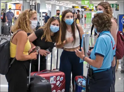  ??  ?? NO ESCAPE: A holiday rep warns British tourists arriving in Majorca last week about the new quarantine rules