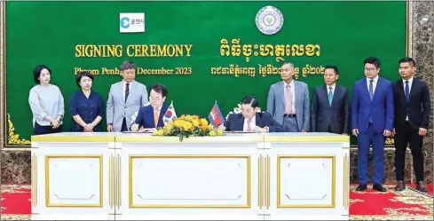  ?? MLVT ?? Labour minister Heng Sour (right, seated) and Chuncheon governor Yook Dong-han sign the document at the ministry on December 27.