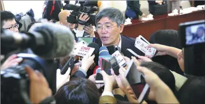  ?? ZOU HONG / CHINA DAILY ?? Yang Weimin, deputy head of the Office of the Central Leading Group on Financial and Economic Affairs and a member of the 13th CPPCC National Committee, speaks with reporters on the sidelines of a CPPCC National Committee meeting in Beijing on Sunday.