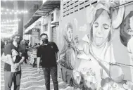  ?? — Gambar Bernama ?? MENARIK: Mohd Sharkar (dua kiri) tertarik dengan salah satu lukisan mural yang menghiasi dinding bangunan semasa melakukan tinjauan di Kuantan Art Street, Kuantan malam kelmarin. Lorong belakang barisan kedai lama di antara Jalan Besar dan Jalan Mahkota yang sebelum ini kelam dan suram kini bertukar lebih ceria dengan hiasan lukisan mural memaparkan kisah rakyat dan identiti negeri selain dihiasi lampu bagi menghidupk­an suasana waktu malam seterusnya menjadi tempat tarikan baharu Bandaraya Kuantan.