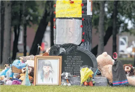  ?? REUTERS ?? Children’s shoes, toys, candy, tobacco and flowers are left on a memorial at the Portage La Prairie Indian Residentia­l School, which closed in 1975, in Portage La Prairie, Man. on Tuesday.