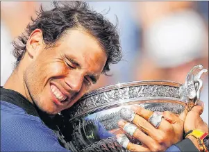  ?? AP PHOTO ?? Spain’s Rafael Nadal holds the trophy as he celebrates winning his 10th French Open title, after defeating Switzerlan­d’s Stan Wawrinka in three sets in Paris in 2017.