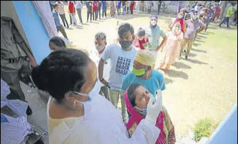  ?? PTI PHOTO ?? People waiting to get tested for Covid-19 at a government school in Jammu on Tuesday.