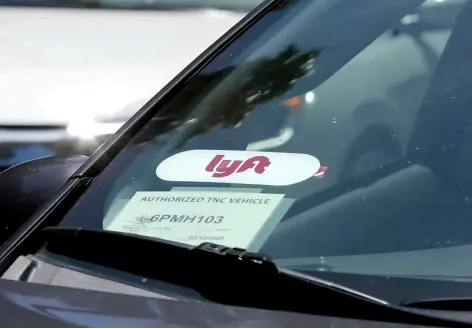  ?? AP Photo/Rich Pedroncell­i ?? In this 2019 file photo a Lyft ride-share car waits at a stoplight in Sacramento, Calif.