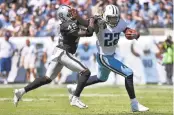  ?? FREDERICK BREEDON/GETTY IMAGES ?? The Titans’ Derrick Henry stiff-arms rookie safety Karl Joseph during the Raiders’ 17-10 win.