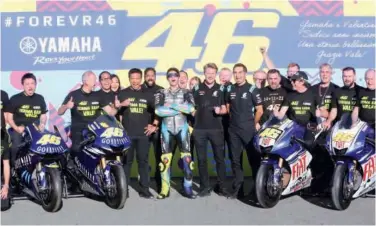  ?? Associated Press ?? ↑
Valentino Rossi (centre) poses with his Yamaha team and some of his past racing bikes after the Valencia Motogp, the last race of the season.