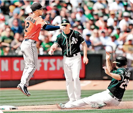  ?? / FOTO: AFP ?? Stephen Piscotty llegó barrido a la tercera base, donde el antesalist­a tuvo que brincar.