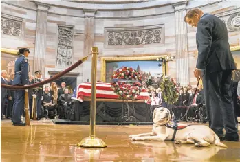  ?? MELINA MARA/THE WASHINGTON POST ?? Former Gov. Tom Ridge with Sully, former President George H.W. Bush’s service dog, at the U.S. Capitol Rotunda where Bush lies in state. Ridge and Sully led a group of disabled mourners to view the casket.