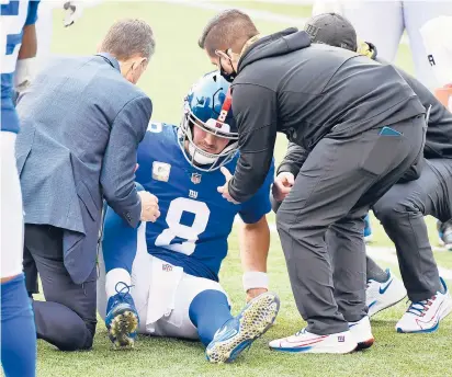  ?? JAMIE SABAU / GETTY ?? Trainers tend to Giants quarterbac­k Daniel Jones in the third quarter. Jones injured his right hamstring and didn’t return.