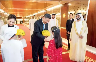  ?? Wam ?? Xi Jinping and Peng Liyuan are presented with flowers upon their arrival at the Presidenti­al Airport in Abu Dhabi on Thursday as Sheikh Mohammed bin Rashid and Sheikh Mohamed bin Zayed look on. —