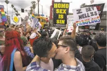  ?? David McNew / Getty Images ?? Men kiss in defiance of a counterpro­test from street preachers during the L.A. Pride Parade that turned into a ResistMarc­h.